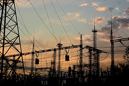Electric substation on a background of the coming sun