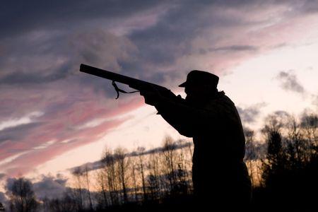 Silhouette of the hunter on a background of a morning dawnの写真素材