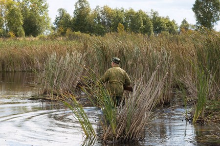 The hunter goes on lake in search of wild ducksの写真素材