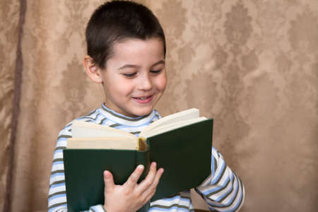 The boy reads the thick bookの写真素材