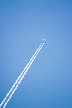 White airplane trace on blue skyの写真素材