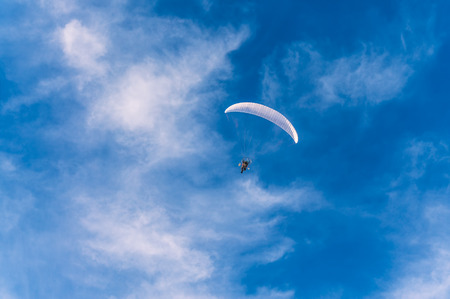Powered paragliding flying against the blue skyの写真素材