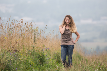 The girl in the field among high yellow grassの写真素材