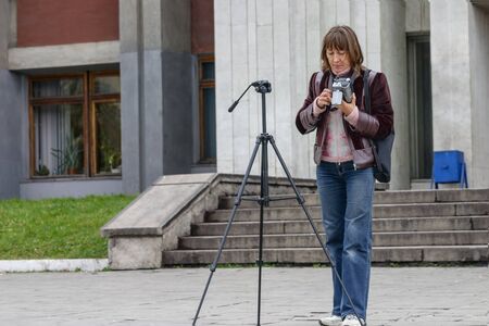 Woman videographer with tripod and amateur camera