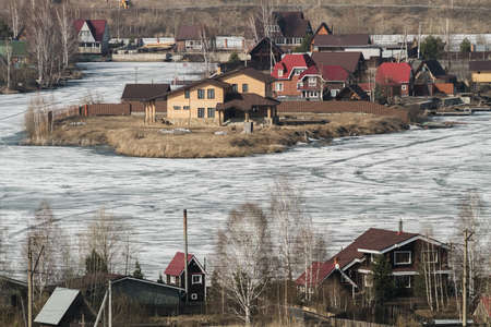 Cottage village in winter on the shore of a frozen lakeの写真素材