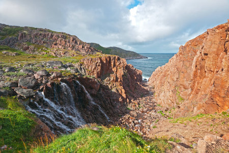 Beautiful landscape with a waterfall, rocks and seaの写真素材
