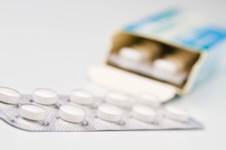 pills in blister package in front of the boxの写真素材