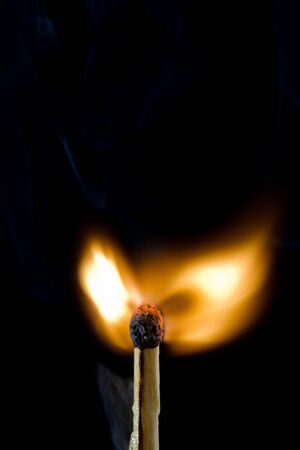 Closeup of match just ignited against black backgroundの写真素材