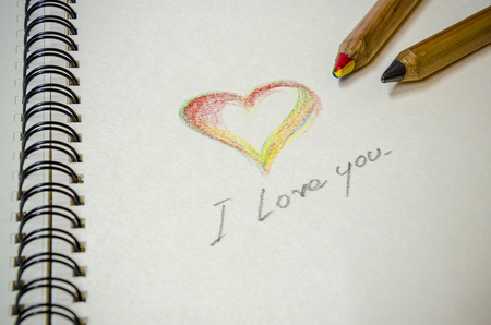 Hand writing of colorful heart and word " i love you " on white note book, Back ground for valentine's dayの写真素材