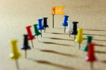 An image of paper and pin on cork board, Selective focus on a yellow flagの写真素材