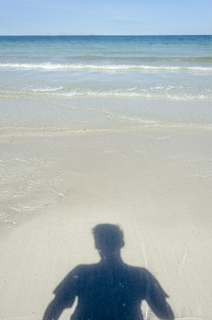 An image of a shadow om man on the beach in the seaの写真素材