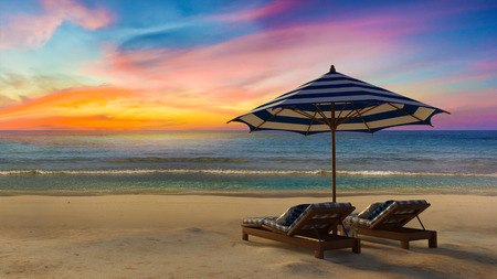 3D rendering image of timber tent which cover by fabric loacted on the beach,  curtain being blow by wind from the sea, white and blue day bed,sunset time perspectiveの写真素材