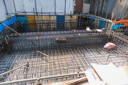 Construction site with iron mesh and Steel Rebars for reinforced concrete.Geometric alignment of Rebars for building foundation.の写真素材