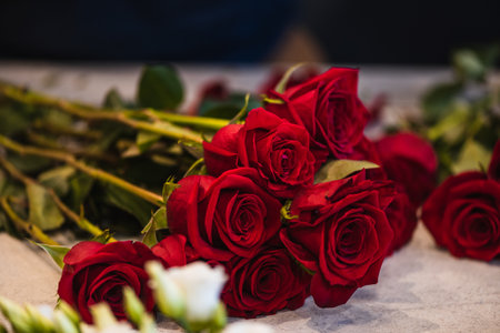 Happy caucasian florist making bouquets of red and pink roses for Valentine's day. Concept of human emotions, facial expression, love, and hard work in this pandemic times.の写真素材