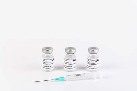San Sebastian, Gipuzkoa, Spain; 03 February 2021. Three Covid-19 vaccine vials with white background and a syringe. SARS-CoV-2 vaccination treatment. Copy space.のeditorial素材