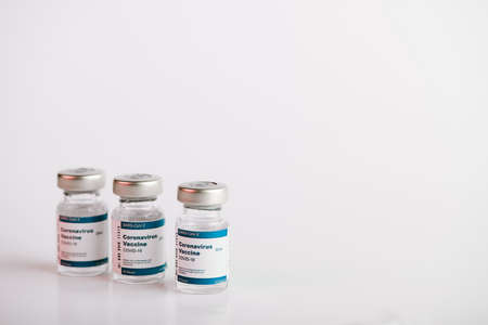 three Covid-19 vaccine vials with white background to inject medical professionals and people at risk .. SARS-CoV-2 vaccination treatment. Copy space.の写真素材