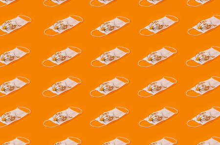Repetitive Pattern Of Medical Face Masks With Flowers And Purple Cancer Background.  Protection Healthy Cancer Concept. Regular Pattern, Flat Lay.の写真素材