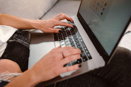 Close up of female hands typing on laptop keyboard at home. Business, working from home, studying...