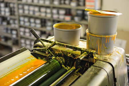 detail of offset printing machine with ink tanks yellow