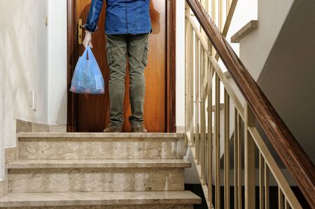 home delivering some groceries at quarantine time because of coronavirus infection COVID-19. Man with protective gloves, delivery of groceries at homeの写真素材