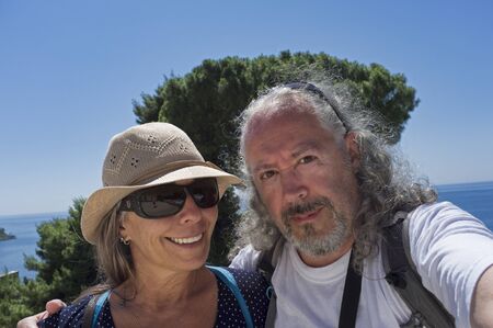 middle-aged couple on vacation at the beach makes a selfie