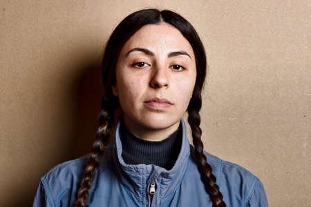 Close up portrait of a girl with no make up, pigtails and blue jacketの写真素材