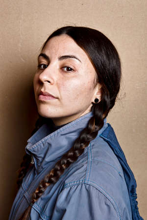 girl without make up and blue jacket, with the same hairstyle as Greta Thunberg, studio shot on brown cardboard backgroundの写真素材