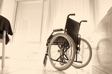 wheelchair against the window, in a bright modern living room or hospital.の写真素材