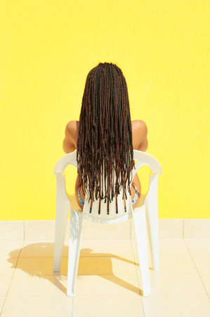 Young beautiful girl with very long braided hair from behind, in bikiniの写真素材