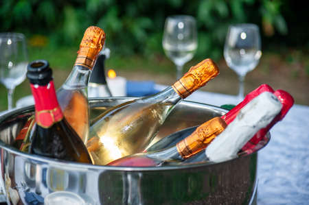 Lots of bottles of champagne or prosecco chilled on ice, by the resort's pool in a luxury hotel. Pool party.の写真素材