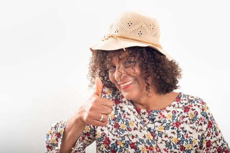 Close-up portrait of smiling Brazilian mature woman, wearing capの写真素材