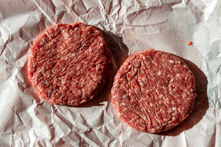 Close-up of juicy and fresh raw hamburgers just taken in the butcher shopの写真素材