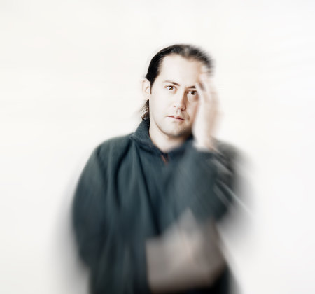 Young man with hand on temple. Concept of youth depression, image with zoom blurの写真素材