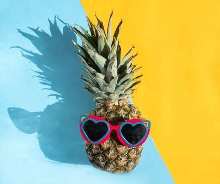 Pineapple hipster in sunglasses. Minimal concept, summer tropical pineapple. Summer, vacation, partyの写真素材