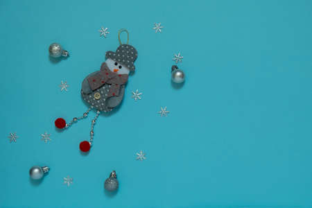 Postcard, frame, banner Merry Christmas and a holiday. New Year. Noel. Silver decor on a blue background top view. Snowman and Christmas balls. Winter Christmas holiday theme. Flat layの写真素材