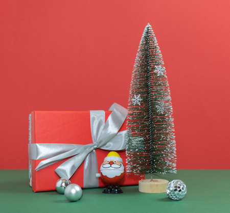 Santa Claus, a big gift is standing next to the New Year tree. Merry Christmas. Happy New Year 2022.の写真素材