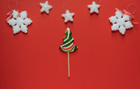 Candy cane in the form of a Christmas tree on a red background.Christmas decorations around a lollipop. Merry Christmas Happy New Year 2022の写真素材
