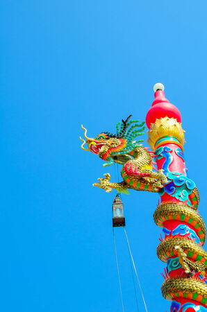 Chinese style dragon statue on column against blue skyの写真素材