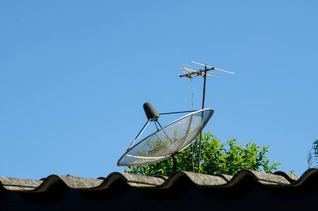 Satellite dish on the house roof and skyの写真素材