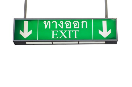 Illuminated green exit sign on isolated white backgroundの写真素材