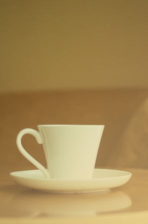 Coffee cup on wood table with vintage blur filter effectの写真素材