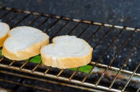 Heart shape toast with butter on rack over stoveの写真素材