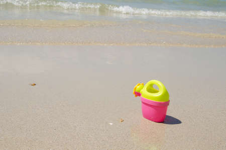 Watering bucket on tropical sand beach in summer seaの写真素材