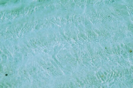 Sand beach background and water surface with color filterの写真素材