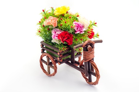Artificial flowers in a cart of wooden tricycle toy for decorative on white background.