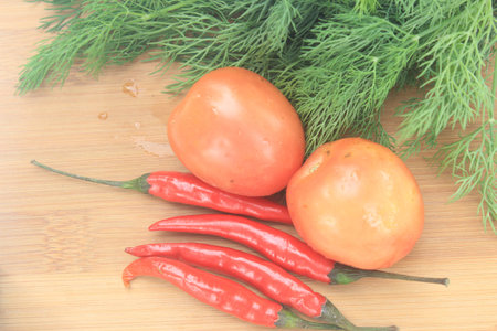 Fresh ingredients for cooking: tomato, chili on wooden backgroundの写真素材