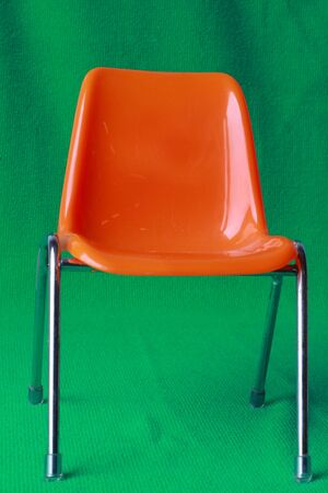 The orange chair on a green background の写真素材