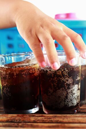 Child holding a glass of cola with ice.の写真素材