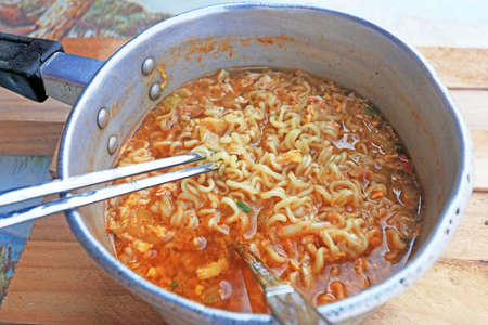 Chopsticks holding asian noodles in potの写真素材
