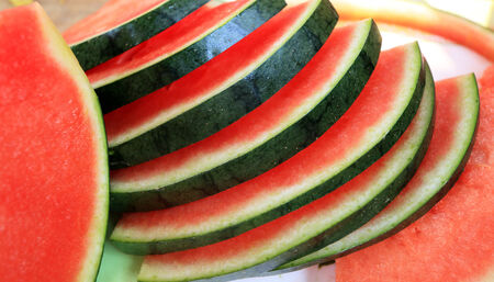 Watermelon fruit sliced pieces on the wooden floor の写真素材
